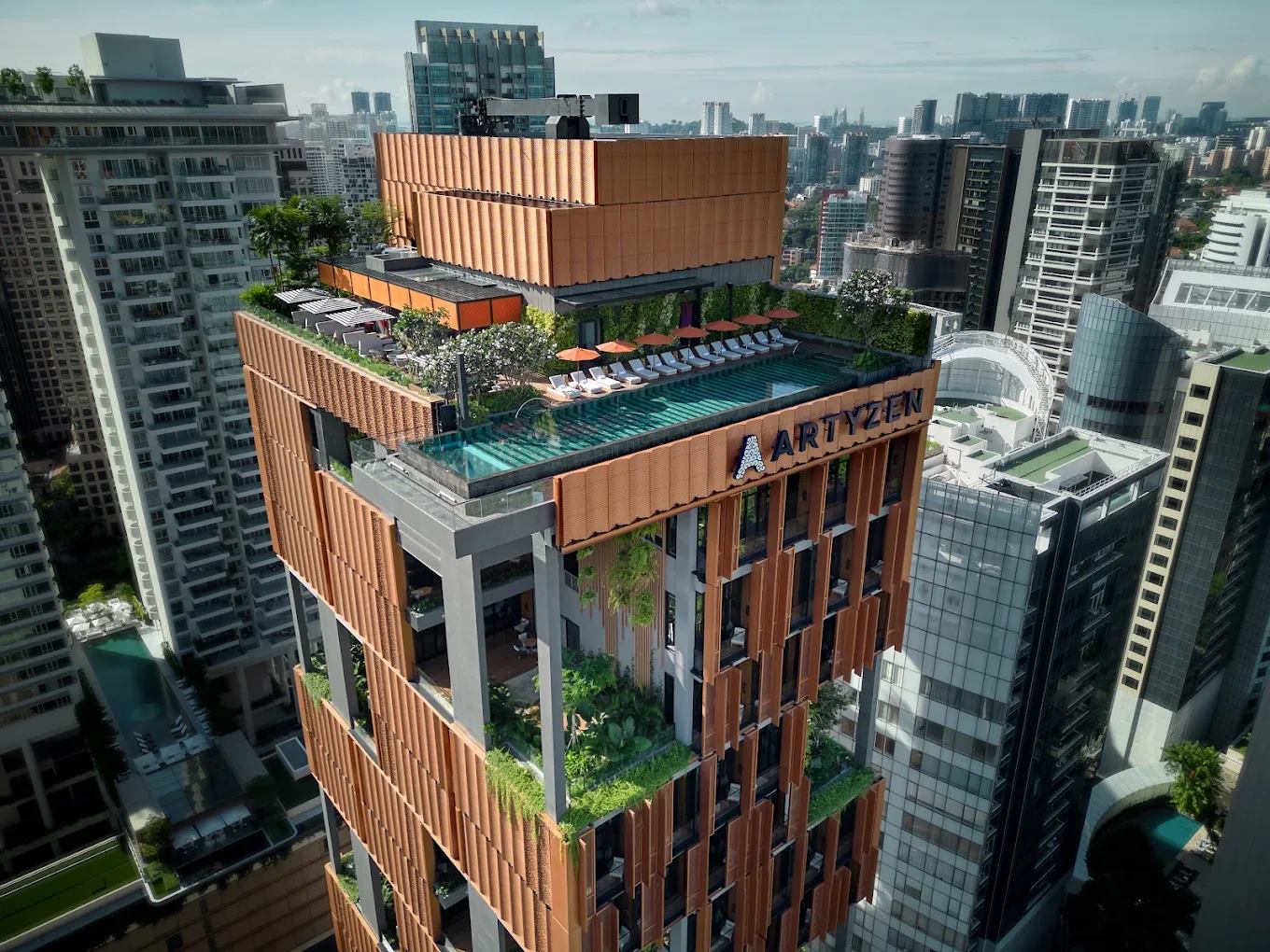 Artyzen Singapore seen from above, with the rooftop pool, terraces and terracotta facade fins